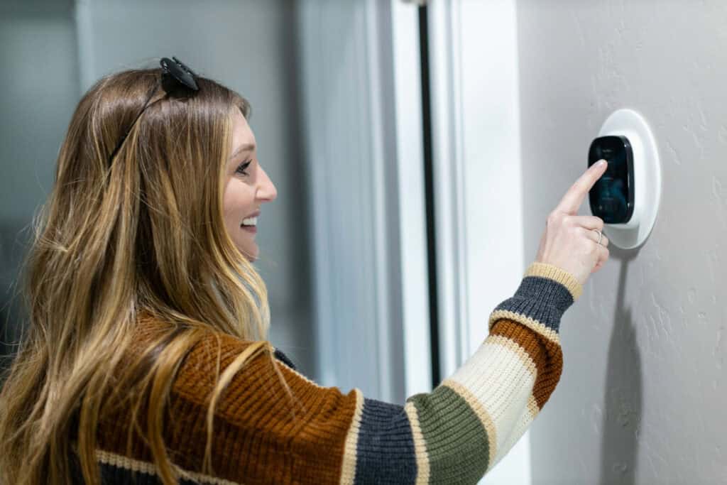 woman checking indoor thermostat